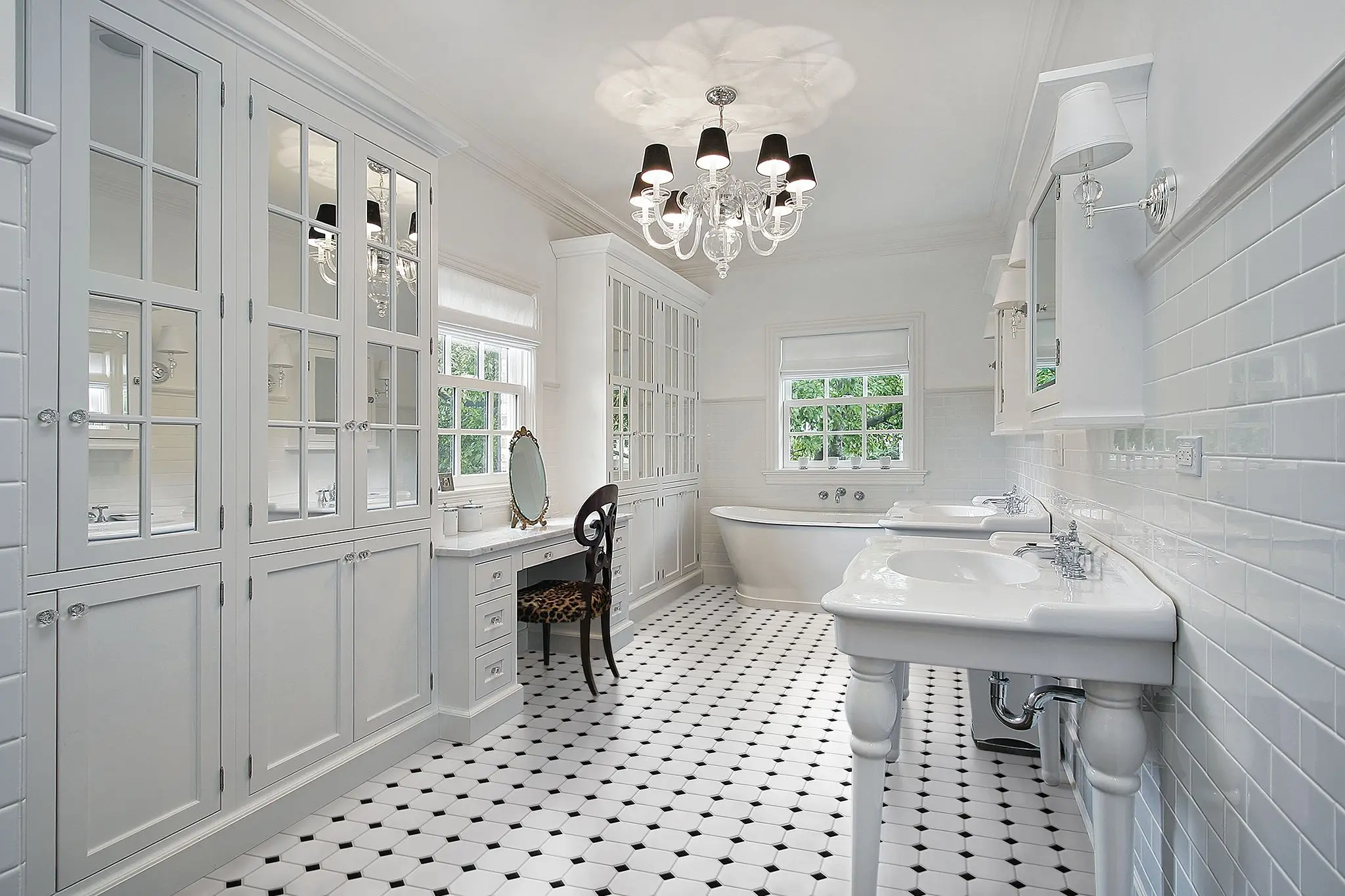 Bathroom design inspiration: a classic all-white bath with black-and-white octagon floor tile, subway-tiled walls, console sinks, and a freestanding tub