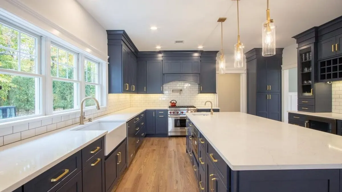 A finished navy and white kitchen with a quartz island, remodeled by Benchmark on the New Hampshire Seacoast