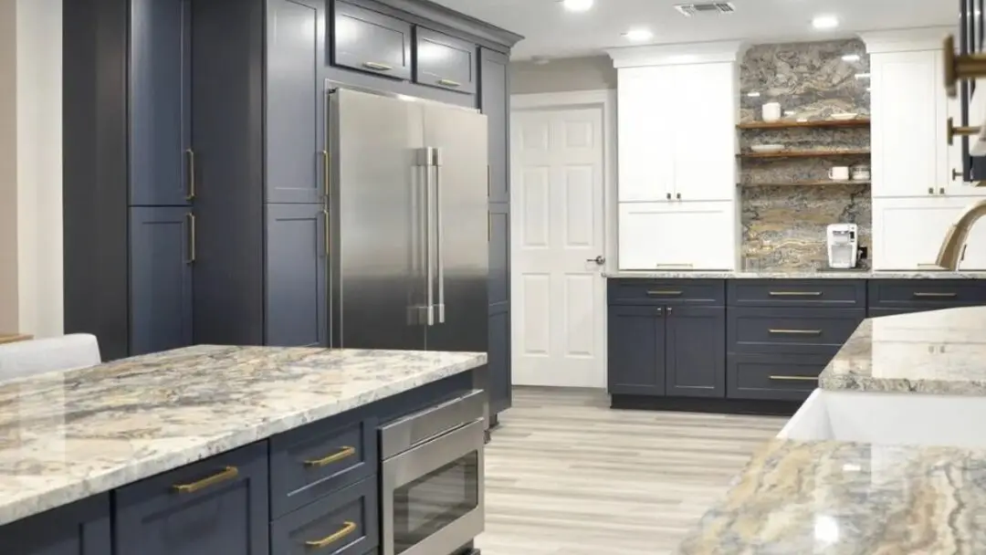 A kitchen island with a stone countertop and waterfall edge in a Seacoast New Hampshire kitchen by Benchmark
