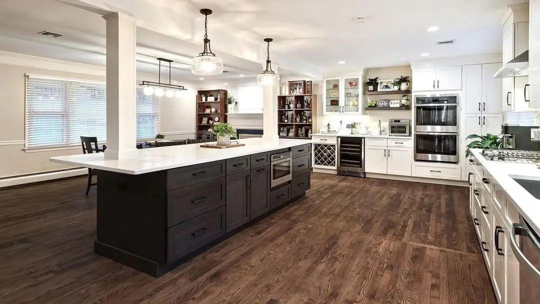 A bright remodeled kitchen with white cabinets and a large island in a Seacoast New Hampshire home by Benchmark
