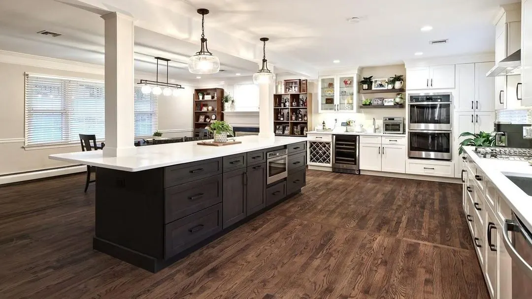 A bright remodeled kitchen with white cabinets and a large island in a Seacoast New Hampshire home by Benchmark