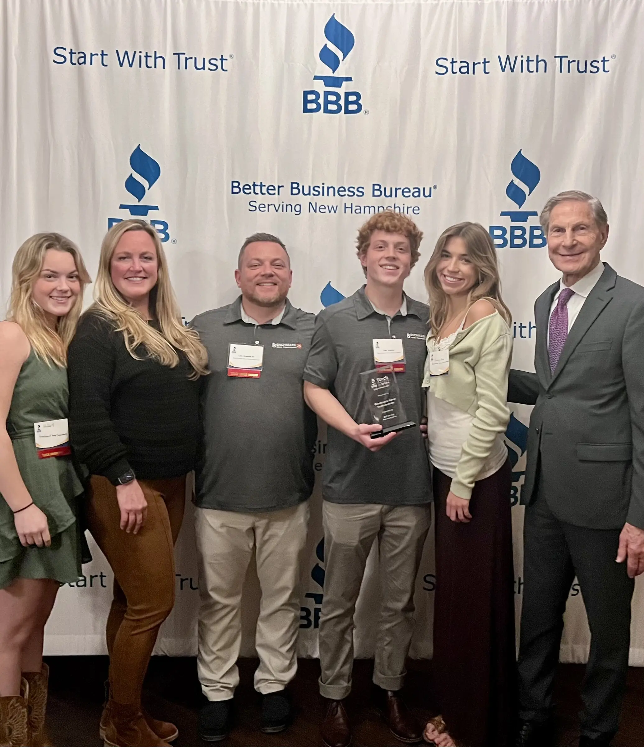 The Veader family holding their BBB Torch Award at the Better Business Bureau of New Hampshire ceremony